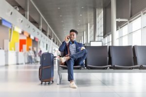 Young man talking on phone at airport lounge